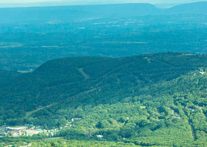 Mount Pocono Observation Air Tour. View is near to ski resort In the center of the picture. Summer season. Green colored trees.